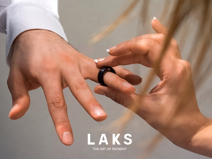 LAKS Pay Ring wird auf einen Finger von einer weiteren Hand geschoben.